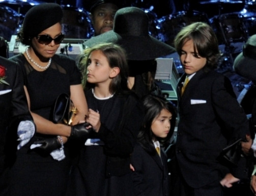As crianças acompanhadas de Janet Jackson no funeral do pai