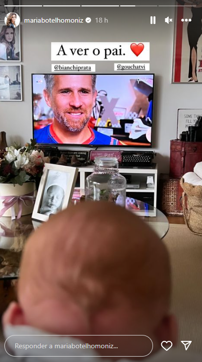 Filho de Maria Botelho Moniz atento ao pai na televisão
