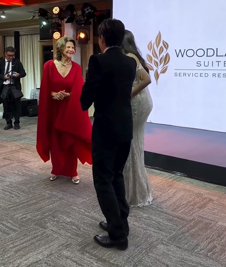De visita à Tailândia, num esvoaçante vestido encarnado, rainha Sílvia da Suécia dança ao som dos ABBA