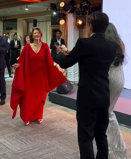 De visita à Tailândia, num esvoaçante vestido encarnado, rainha Sílvia da Suécia dança ao som dos ABBA